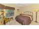 Comfortable bedroom featuring soft carpet, a queen-size bed, and a sun-drenched window at 1018 Yosemite Dr, Englewood, FL 34223