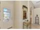 Charming foyer with view of front door, decorative mirror, and glimpse of the kitchen at 1018 Yosemite Dr, Englewood, FL 34223