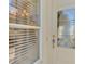 Close-up of the front door, sidelight, and window featuring blinds at 1018 Yosemite Dr, Englewood, FL 34223