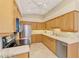 Bright kitchen featuring wood cabinetry, stainless steel appliances, tile backsplash, and a large sink at 1018 Yosemite Dr, Englewood, FL 34223