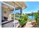 Enjoy the tranquil water view from this screened lanai with comfortable seating and a ceiling fan at 1018 Yosemite Dr, Englewood, FL 34223