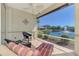 Serene water view from the screened lanai featuring comfortable lounge chairs and tile flooring at 1018 Yosemite Dr, Englewood, FL 34223