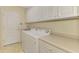 Efficient laundry room with a washer, dryer, sink, storage cabinets, and counter space at 1018 Yosemite Dr, Englewood, FL 34223