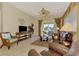 Living room with leather furniture, neutral tile flooring, and sliding doors that open to a view of the lake at 1018 Yosemite Dr, Englewood, FL 34223