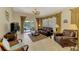 Living room with leather furniture, neutral tile flooring, and a large window view of the lake with a ceiling fan at 1018 Yosemite Dr, Englewood, FL 34223