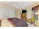 Cozy main bedroom with a large closet, dresser with a TV, and a window with natural light at 1018 Yosemite Dr, Englewood, FL 34223