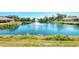 Panoramic view of a serene pond with a fountain, surrounded by lush greenery and manicured lawns at 1018 Yosemite Dr, Englewood, FL 34223