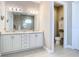 Elegant bathroom featuring double vanities, modern lighting, and access to toilet area at 10346 Medjool Dr, Venice, FL 34293