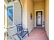 Charming front porch with brick flooring, stylish bench, and a decorative front door creating a welcoming entrance at 10346 Medjool Dr, Venice, FL 34293