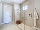 Modern bathroom with glass-enclosed shower, neutral tile, and convenient grab bars at 10346 Medjool Dr, Venice, FL 34293