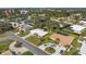 Aerial view showcasing home with white roof, beautiful landscaping, and surrounding residential neighborhood near a bay at 107 Corot Dr, Nokomis, FL 34275