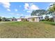 Inviting single-story residence with a white roof, an attached garage, and a lush green lawn at 107 Corot Dr, Nokomis, FL 34275