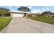 Charming single-story home with a large front yard and a spacious driveway leading to an attached garage at 107 Corot Dr, Nokomis, FL 34275