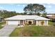 Charming single-story home with a well-manicured front lawn, two-car garage, and white roof at 107 Corot Dr, Nokomis, FL 34275