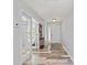 Inviting hallway with wood-look floors, white walls, doors with glass, and coat rack at 107 Corot Dr, Nokomis, FL 34275