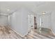 Spacious hallway with wood-look floors, white walls, glass paneled doors, and overhead lighting at 107 Corot Dr, Nokomis, FL 34275