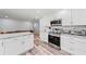 Modern kitchen features stainless steel appliances, white cabinets, and marble countertops at 107 Corot Dr, Nokomis, FL 34275