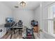 Bright office features a glass desk, modern lighting, and wood-look flooring at 107 Corot Dr, Nokomis, FL 34275