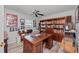 Bright home office featuring a bookshelf and a large wooden desk at 107 Corot Dr, Nokomis, FL 34275