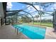 Enclosed pool area with a large screened-in enclosure and a clear blue swimming pool at 107 Corot Dr, Nokomis, FL 34275