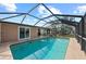Back view of the enclosed pool area, showing sliding doors and an outdoor seating area at 107 Corot Dr, Nokomis, FL 34275