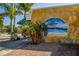 Vibrant beach mural adorning a building exterior, complemented by tropical foliage and a sunny sky at 10768 Trophy Dr, Englewood, FL 34223