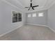 Spacious bedroom with a tray ceiling, tiled floor, and three windows at 10768 Trophy Dr, Englewood, FL 34223