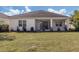 Home's rear exterior with a screened patio and manicured lawn, offering a serene outdoor space at 10768 Trophy Dr, Englewood, FL 34223