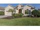 Inviting front exterior showcasing lush landscaping, a well-maintained lawn, and a charming single-story home at 10768 Trophy Dr, Englewood, FL 34223