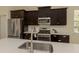 Close up of kitchen sink, stainless steel appliances, and quartz countertops at 10768 Trophy Dr, Englewood, FL 34223