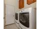 Bright laundry area with front loading washer and dryer and built in cabinets above appliances at 10768 Trophy Dr, Englewood, FL 34223