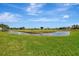 Scenic view of the pond with green lawn at 1100 Capri Isles Blvd # 422, Venice, FL 34293