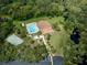 Aerial view of community clubhouse, pool, tennis courts, and lush landscaping at 1118 Southlake Ct, Venice, FL 34285