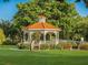 Scenic gazebo surrounded by a lush green lawn and mature trees at 1118 Southlake Ct, Venice, FL 34285