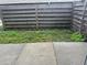 The backyard features a mix of concrete and natural ground with a wood fence at 1190 Longfellow Way # 135C, Sarasota, FL 34243