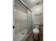 Bathroom featuring a tiled shower with sliding glass door and a standard toilet at 1190 Longfellow Way # 135C, Sarasota, FL 34243