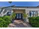 Clubhouse entrance featuring double doors, brick pathway, and manicured landscaping at 1190 Longfellow Way # 135C, Sarasota, FL 34243