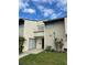 Two-story townhouse featuring a lawn with various green landscaping and a bright sky at 1190 Longfellow Way # 135C, Sarasota, FL 34243