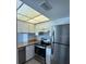Stainless steel appliances with white cabinets and marble countertops in a compact kitchen at 1190 Longfellow Way # 135C, Sarasota, FL 34243