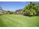 Manicured backyard featuring healthy green grass, mature landscaping and a screened-in lanai at 11917 Hunters Creek Rd, Venice, FL 34293