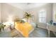 Bright bedroom with wood-look floors, shutters, and a cheerful yellow bedspread at 11917 Hunters Creek Rd, Venice, FL 34293