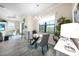 Bright breakfast nook with glass table, chandelier, and large window overlooking the green landscape at 11917 Hunters Creek Rd, Venice, FL 34293