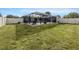 Expansive backyard featuring a screened-in pool, outdoor seating, and lush green grass at 1200 Yawl Way, Venice, FL 34285
