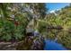 Idyllic waterfront view with a private wooden dock surrounded by lush greenery and calm water reflections at 1200 Yawl Way, Venice, FL 34285