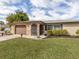 Charming single-story home featuring a stone facade, well-maintained lawn, and inviting curb appeal at 1200 Yawl Way, Venice, FL 34285