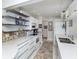 Updated kitchen with sleek white cabinets, modern appliances, open shelving, and decorative backsplash at 1200 Yawl Way, Venice, FL 34285