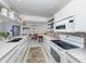 Modern kitchen featuring white cabinets, decorative backsplash, and open shelving at 1200 Yawl Way, Venice, FL 34285
