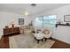 Bright and airy living room with wood floors, large windows, and eclectic decor at 1200 Yawl Way, Venice, FL 34285