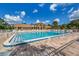 Sunny community pool with ample seating and beautiful landscaping at 1200 Yawl Way, Venice, FL 34285