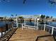 Image of the home's private wooden dock and boat lift on the tranquil canal at 12613 4Th Isle, Hudson, FL 34667